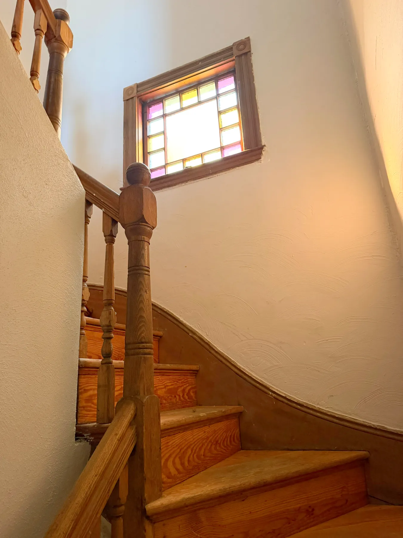 Original wood staircase and stained glass window
